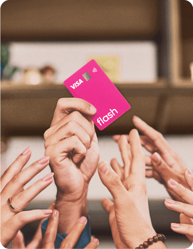 Mão ergue o cartão rosa de benefícios da Flash com a bandeira Visa.