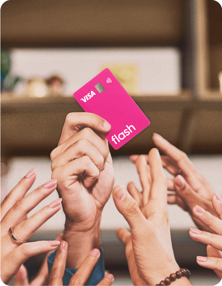 Mão ergue o cartão rosa de benefícios da Flash com a bandeira Visa.