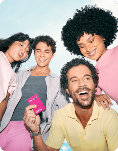 Grupo diverso de quatro colaboradores sorri e celebra junto ao ar livre.